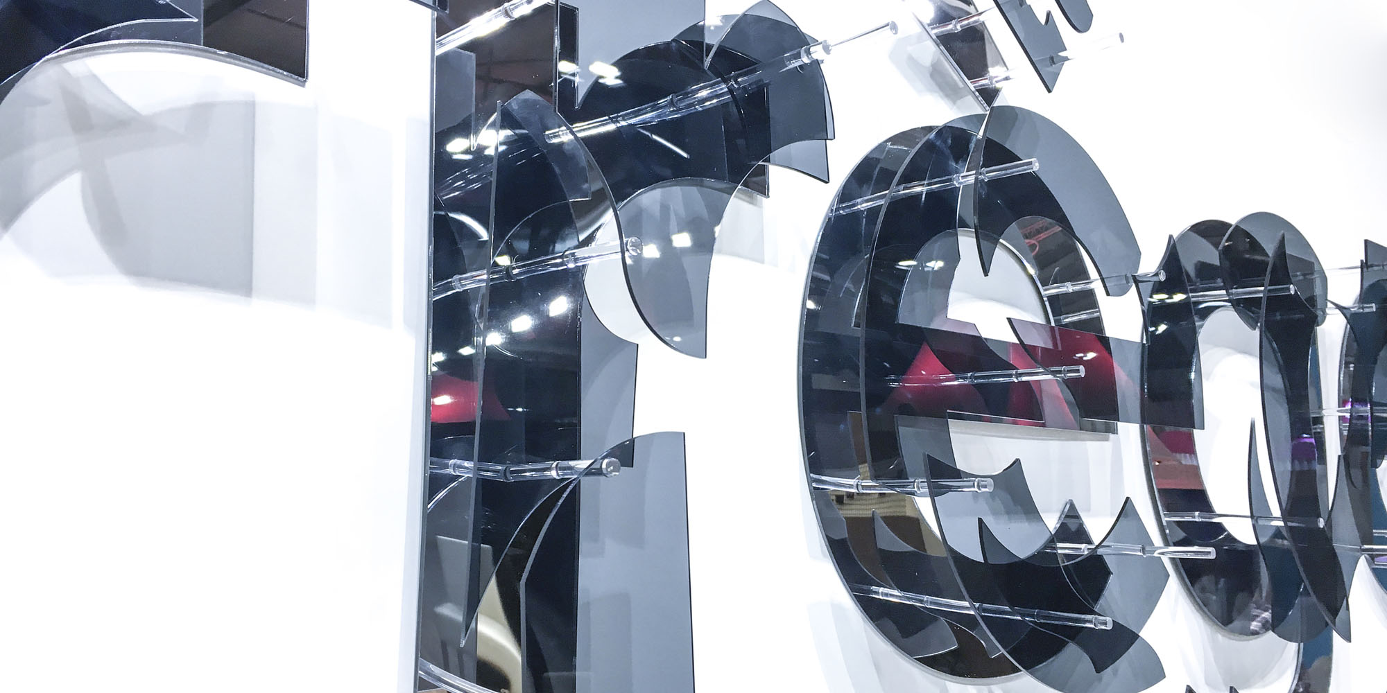 décomposition Courrèges en pièces de plexiglas noir translucide et miroir inspirées du motif de la collection lunettes 2017 de la marque: réalisation d’une enseigne de 4 mètres de long destinée à orner le stand de la marque sur le Mido Eyewear Show à Milan